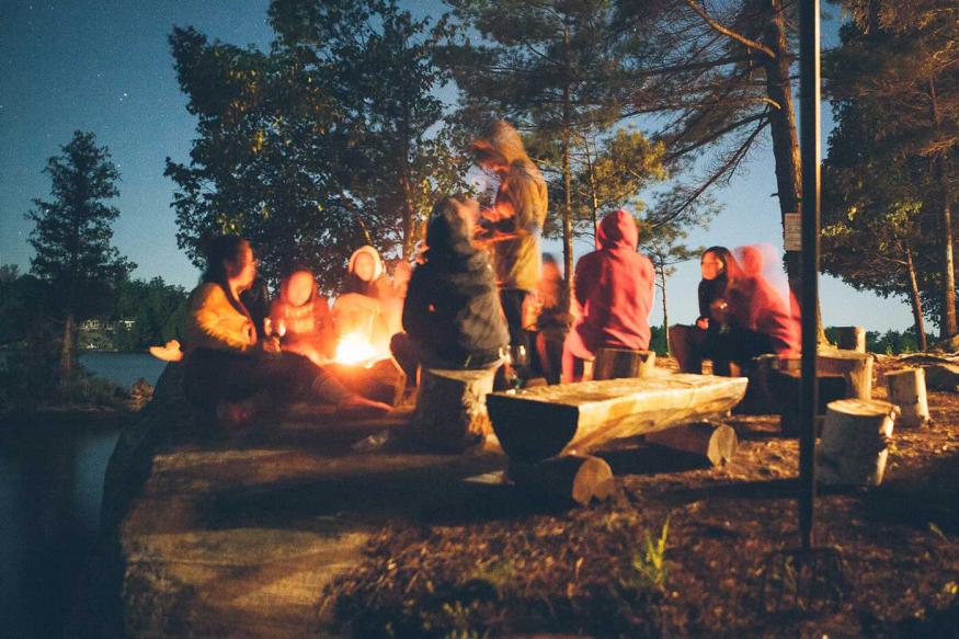 Group of friends around a campfire at night