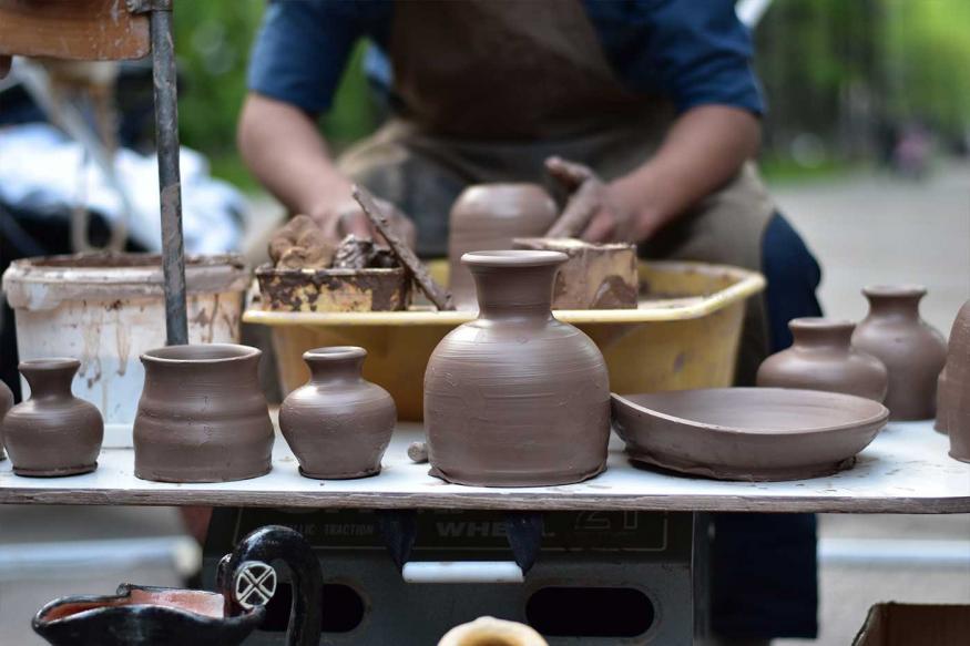 Man turning clay pots and vases on a wheel