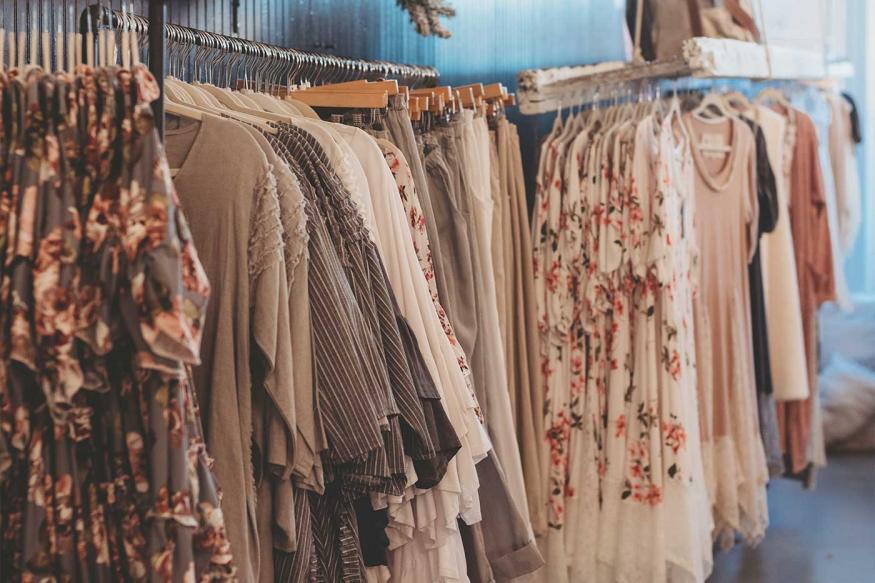 Shirts, pants, and dresses on racks at a fashionable clothing store in Holmes County