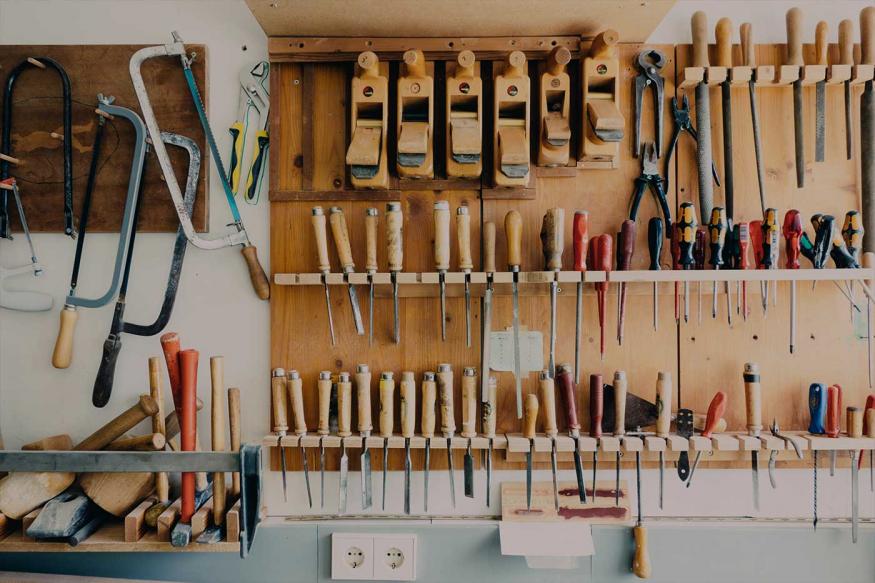 Workshop wall covered in hanging tools for woodworking