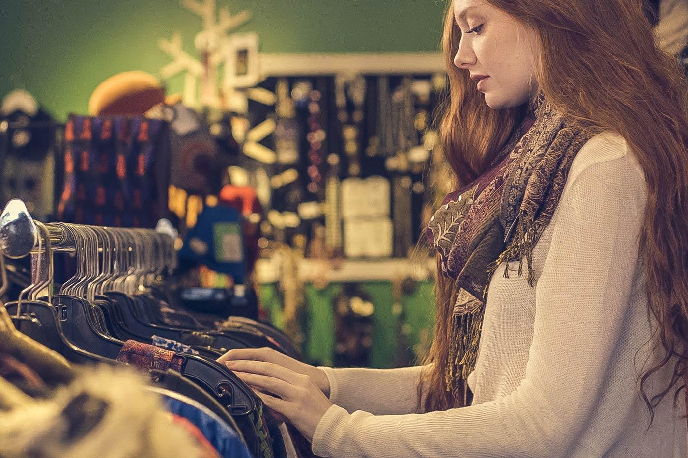 Woman looking at vintage clothing in a thrift store