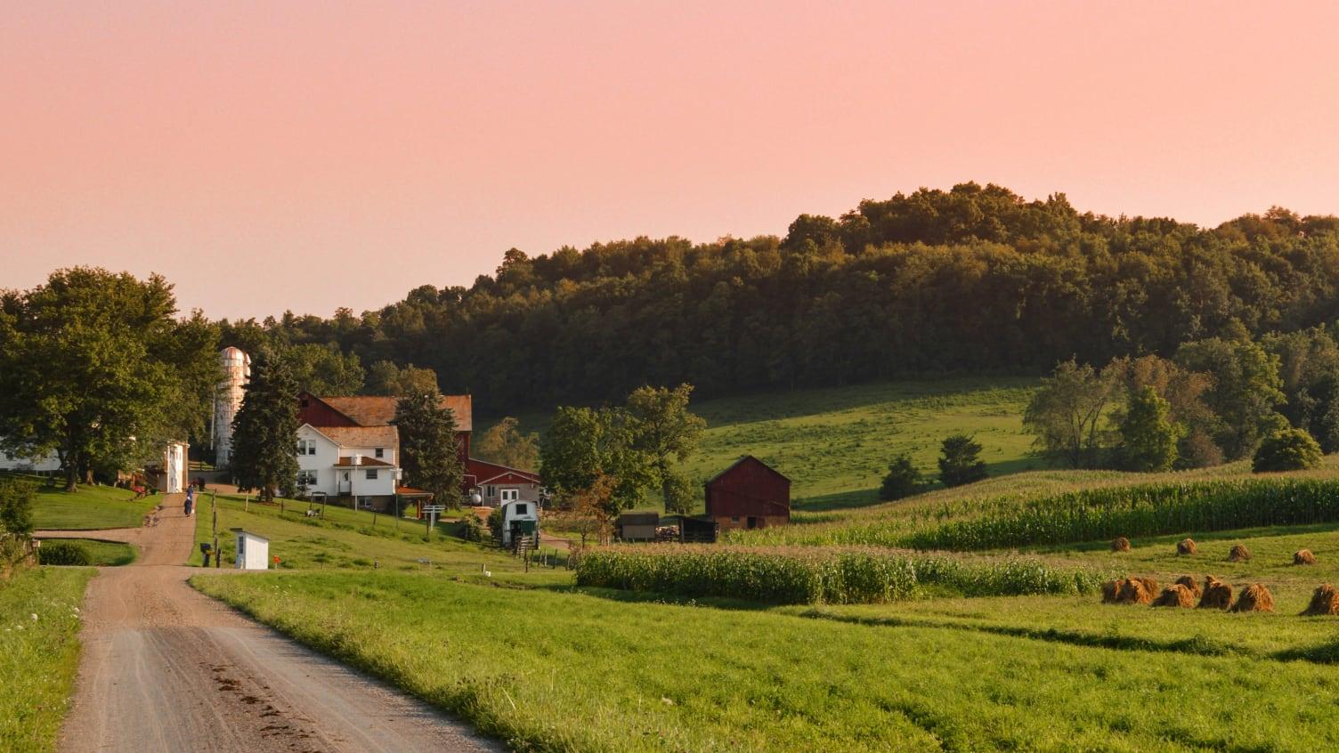 Sunset behind a hill that overlooks an Amish farm