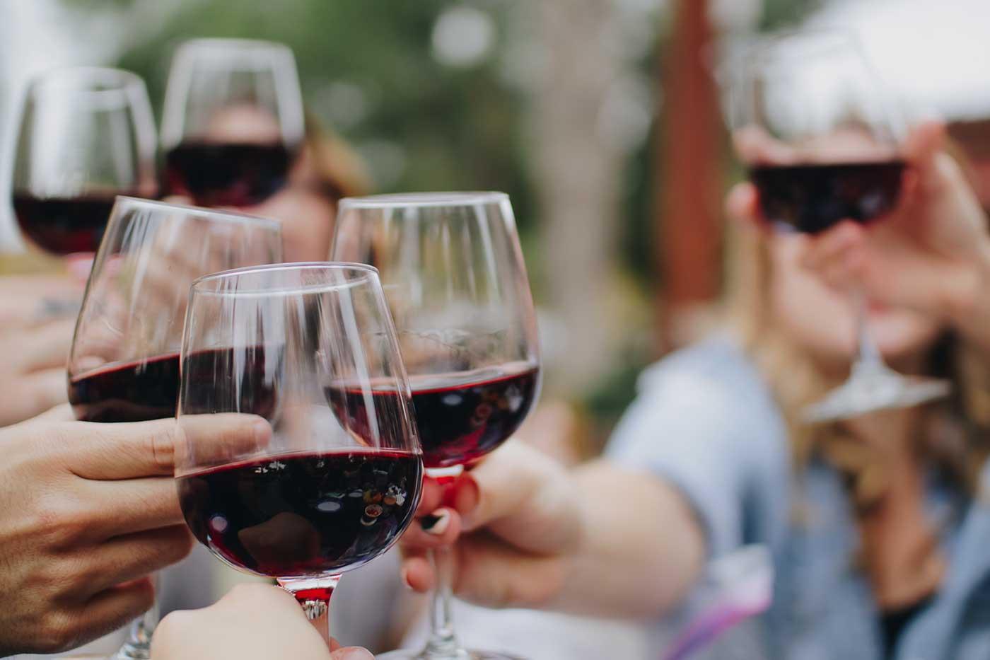 Group of friends toasting with red wine